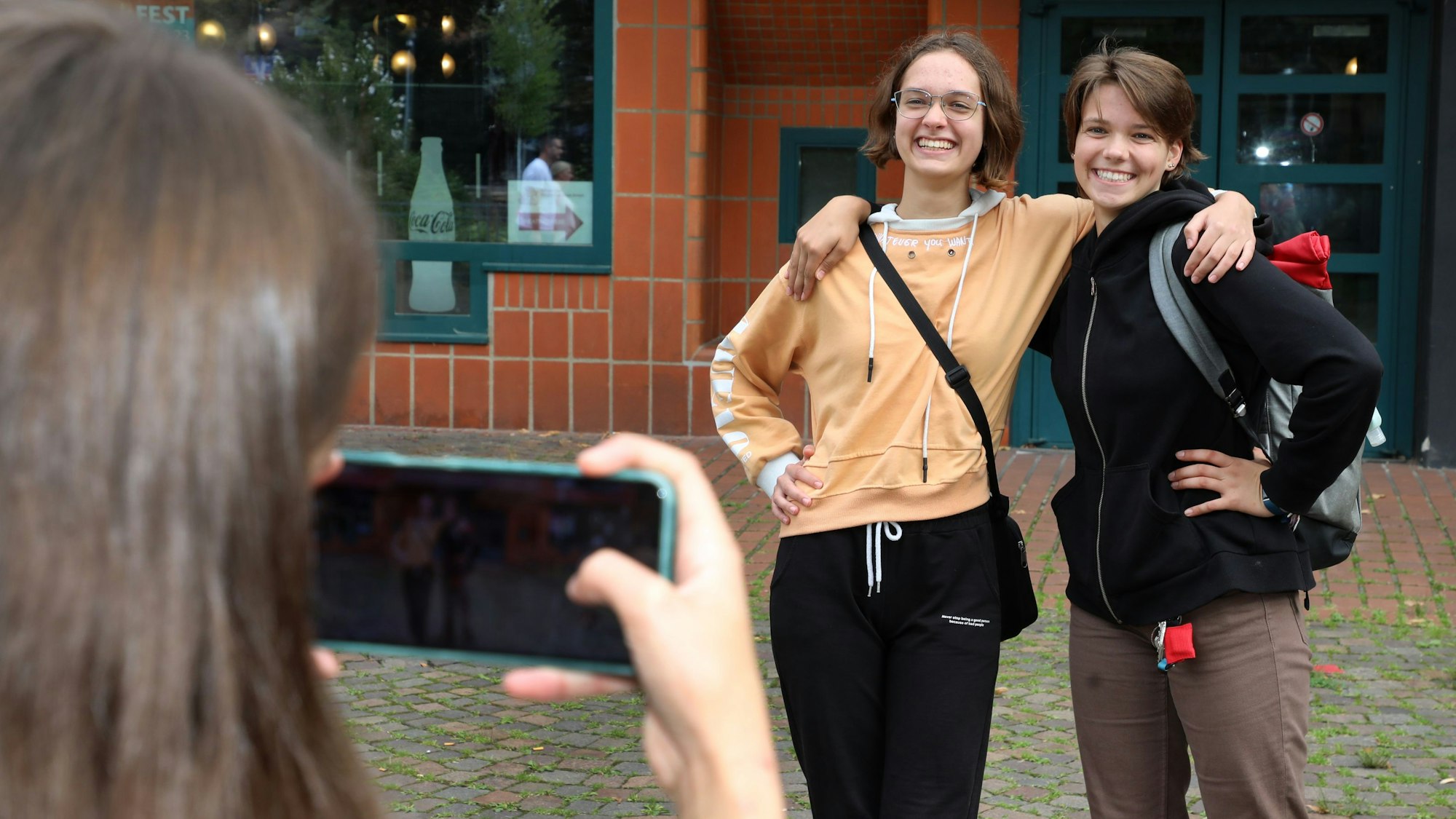 Zwei Mädchen lassen sich vor dem Bürgerhaus Bergischer Löwe fotografieren.