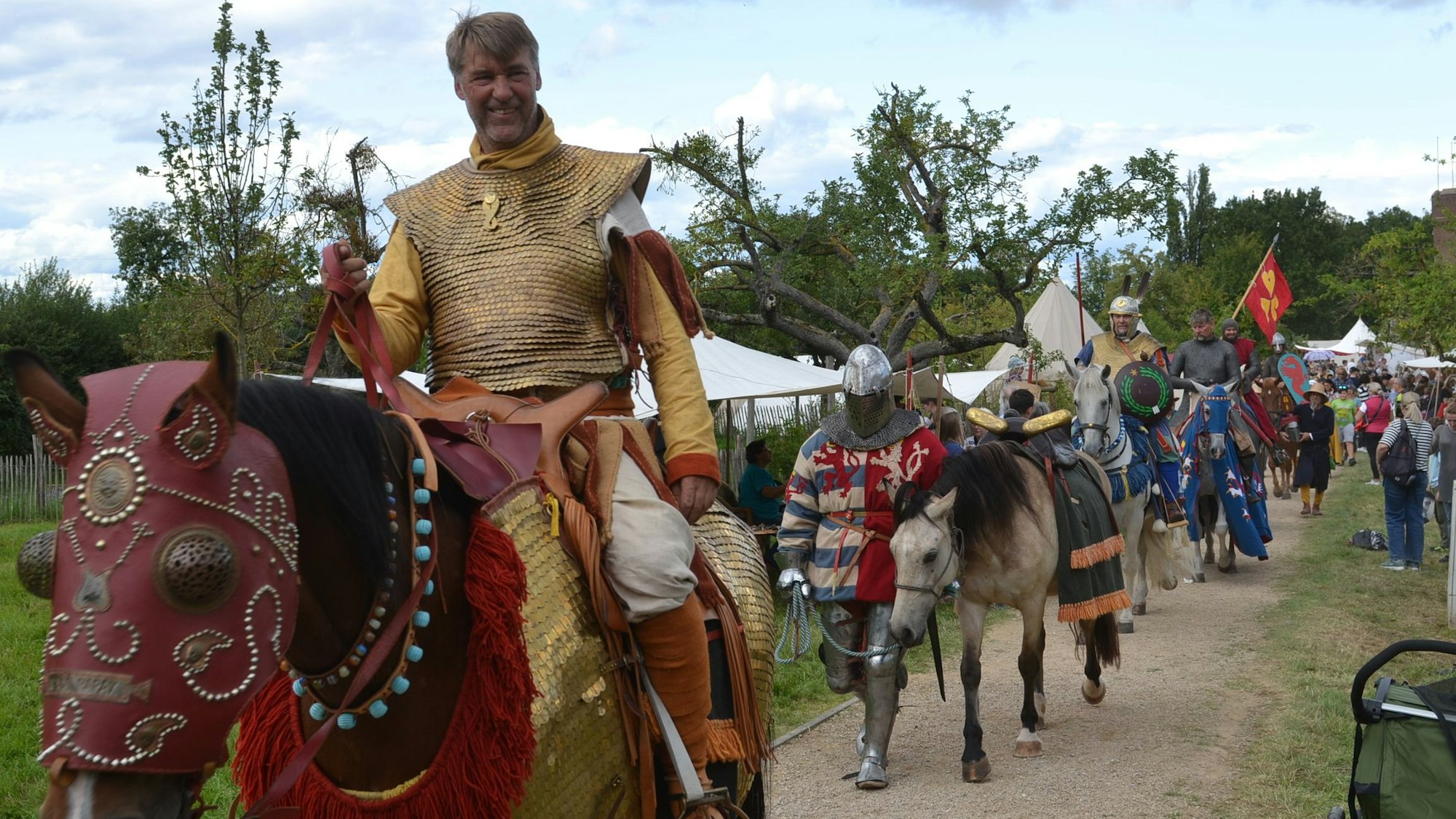 Beim Zülpicher Mittelalterfest reitet ein in historisch passender Rüstung gewandeter Darsteller eines Ritters auf einem Pferd.