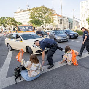 München: Polizisten rennen auf der Kreuzung am Stachus in der Innenstadt zu Teilnehmern· der Letzten Generation, die eine Straße blockieren. (Symbolbild)