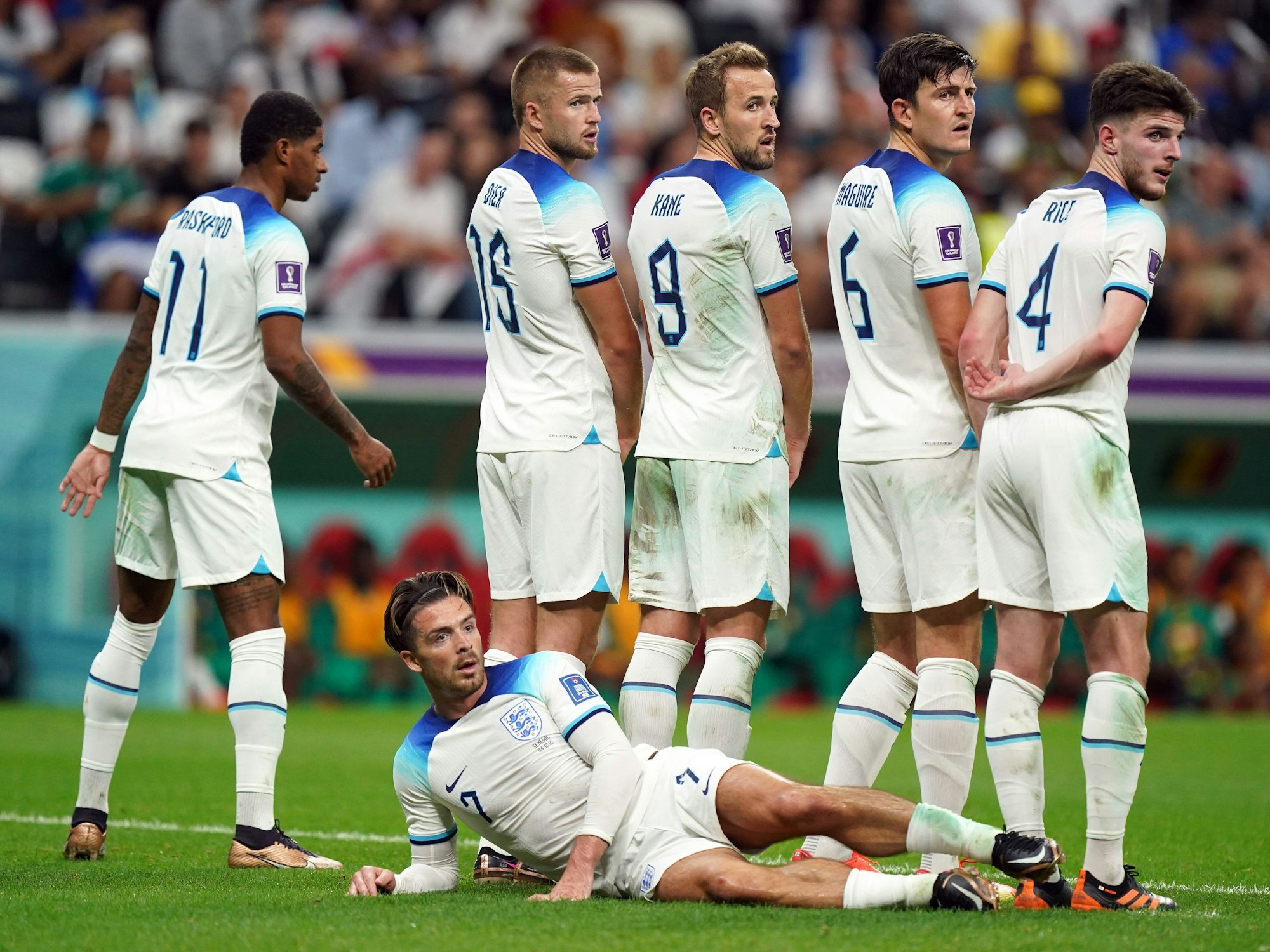 Die in der Mauer stehenden Marcus Rashford, Eric Dier, Harry Kane, Harry Maguire, Declan Rice und der liegende Jack Grealish warten bei der WM 2022 auf einen Freistoß der Senegalesen.
