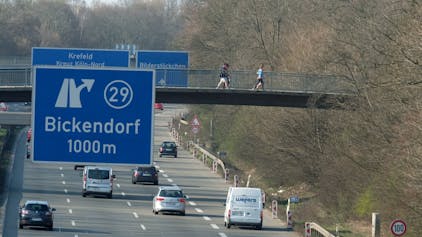 Auf der Stadtautobahn A57 fahren Autos. Ein blaues Schild zeigt die Ausfahrt 29 nach Bickendorf in 1000 Metern an.