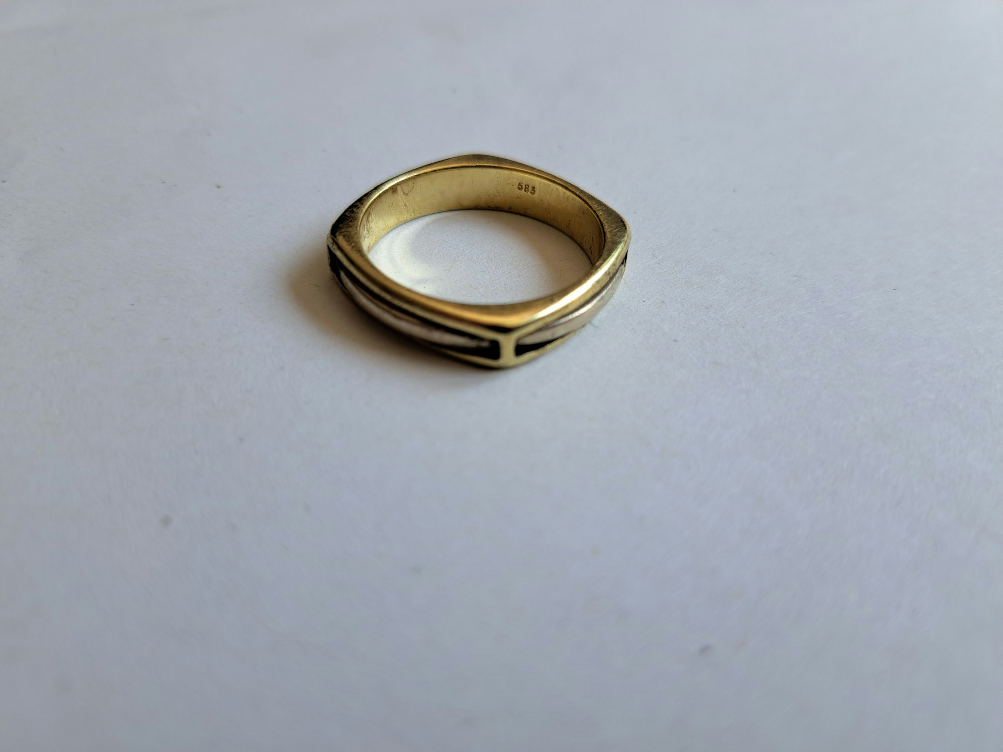 Ein golgender Ring auf einem weißen Tisch.
