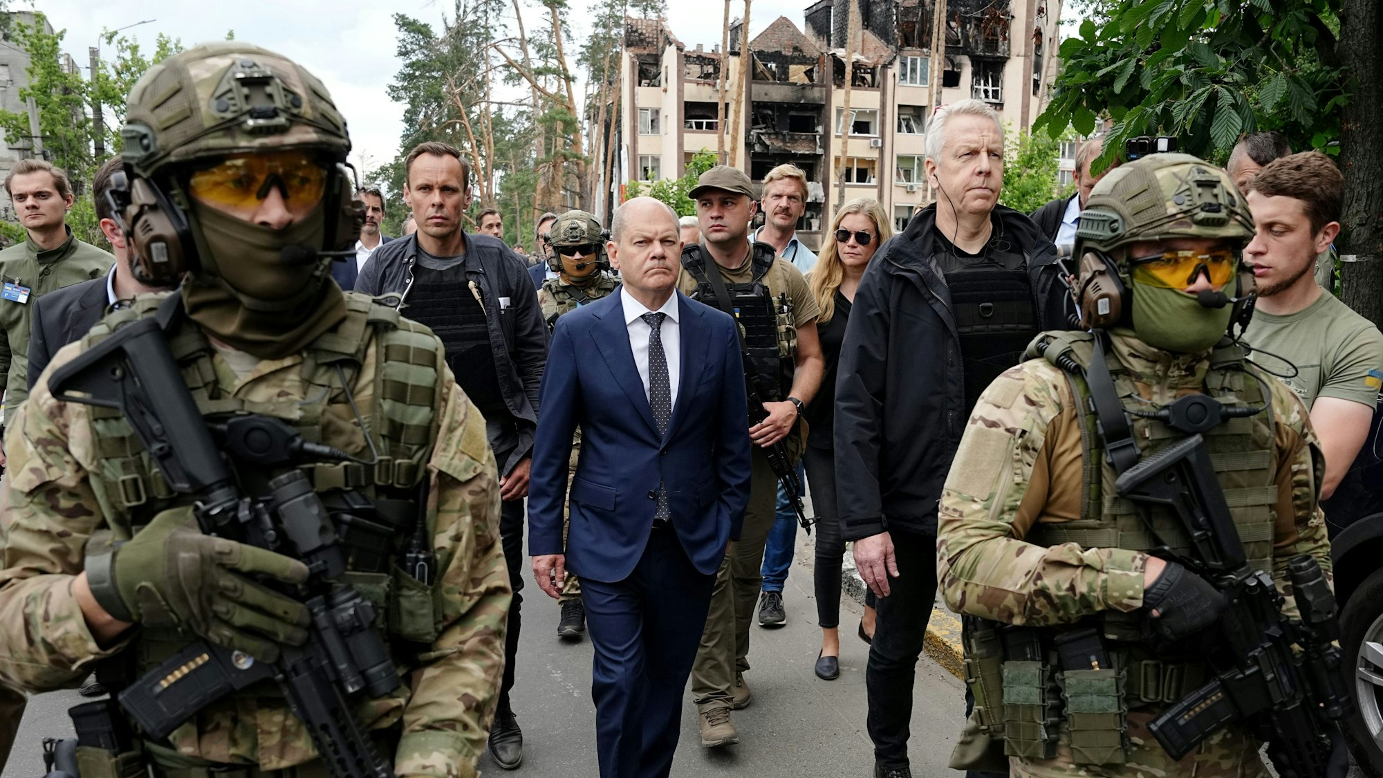 Bundeskanzler Olaf Scholz (Mitte, SPD) bei seinem Besuch im Sommer 2022 in der Ukraine. Auf dem Foto geht er an zerstörten Gebäuden in Irpin im Großraum Kyjiw vorbei.