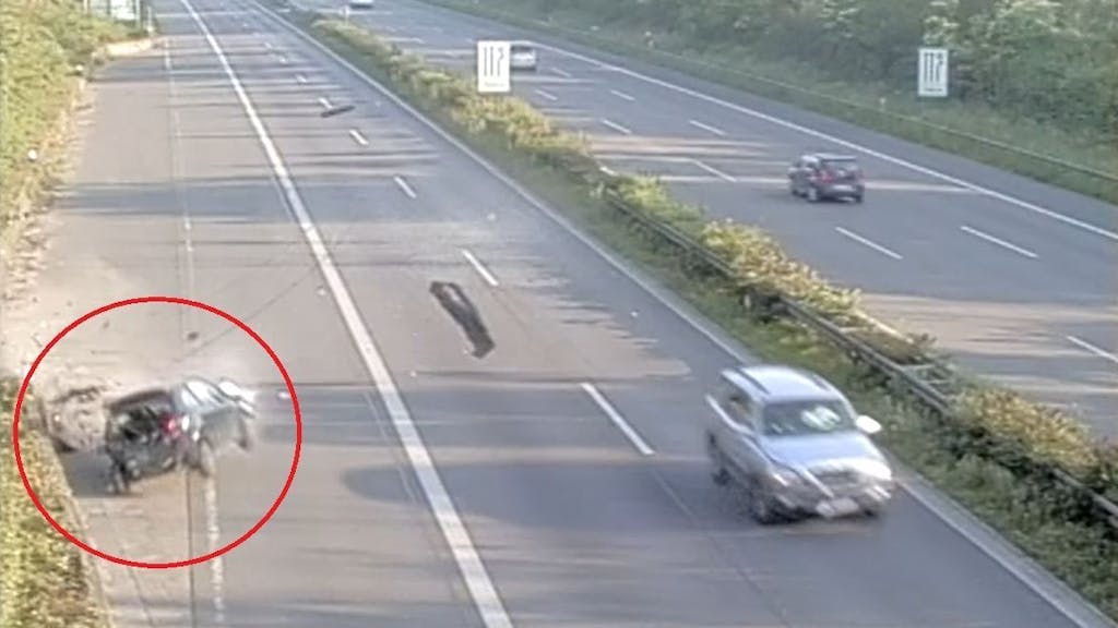 Screenshot aus einem Video, das einen Unfall auf der Autobahn zeigt. Ein schwarzer Peugeot prallt in die Mauer.
