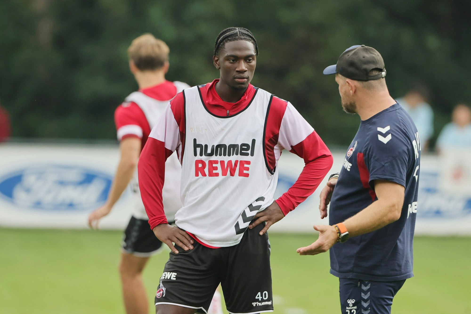 Faride Alidou spricht im Training des 1. FC Köln mit Steffen Baumgart.