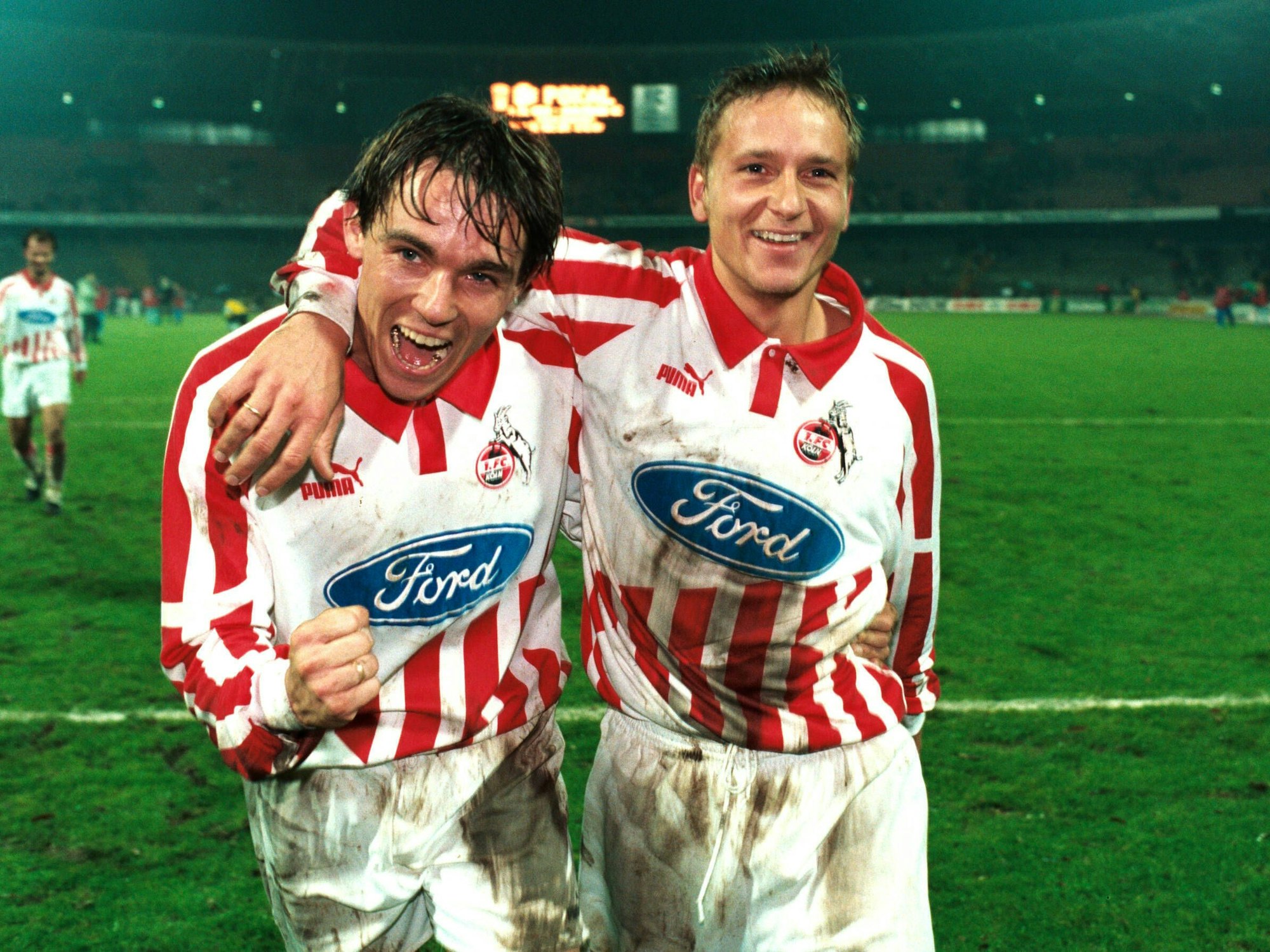 Horst Heldt und Olaf Jansen feiern gemeinsam einen Sieg des 1. FC Köln.