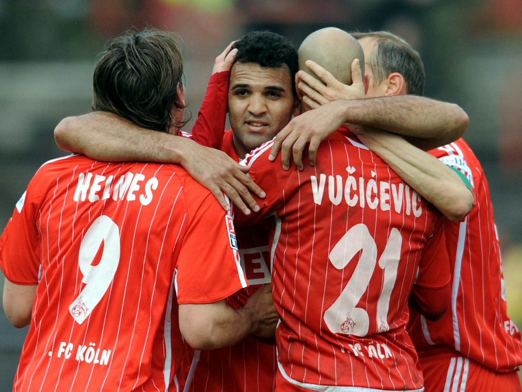 Patrick Helmes, Nemanja Vucicevic und Matthias Scherz umarmen ihren FC-Mitspieler Roda Antar.