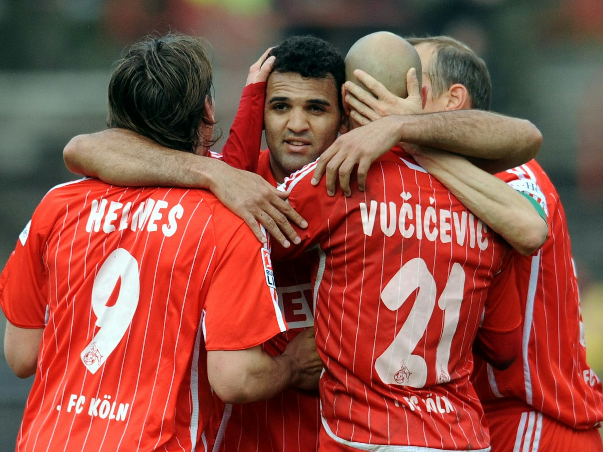 Patrick Helmes, Nemanja Vucicevic und Matthias Scherz umarmen ihren FC-Mitspieler Roda Antar.