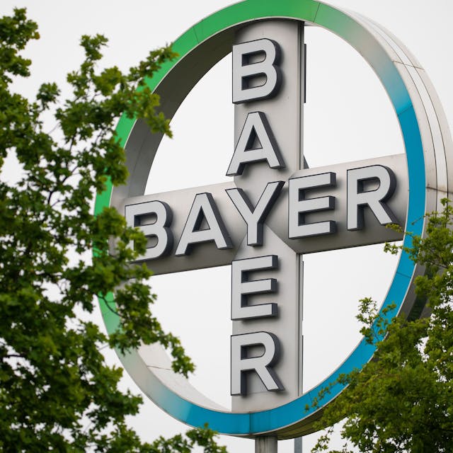 Das Bayer Kreuz, Logo des Unternehmens Bayer, steht zwischen Bäumen am Flughafen Köln/Bonn. Der Agrarchemie- und Pharmakonzern Bayer verkauft seine Tierarzneimittel-Sparte für 7,6 Milliarden US-Dollar (6,85 Mrd Euro) an den US-Konzern Elanco. Das teilte Bayer am Dienstag in Leverkusen mit. +++ dpa-Bildfunk +++