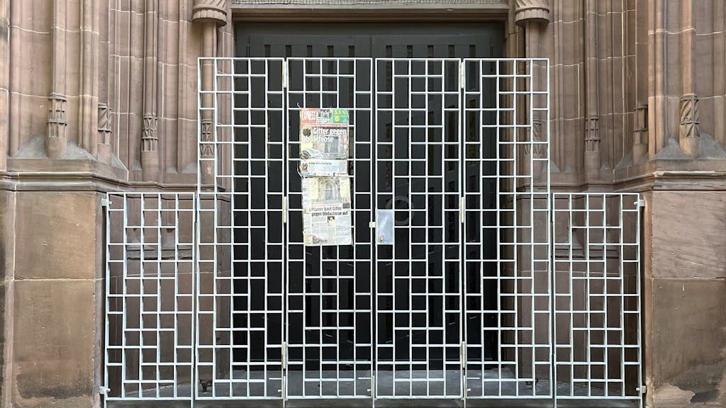 Ein EXPRESS-Artikel hängt mittlerweile am Schutzgitter gegen Obdachlose an der „St. Apollinaris“-Kirche in Oberbilk.