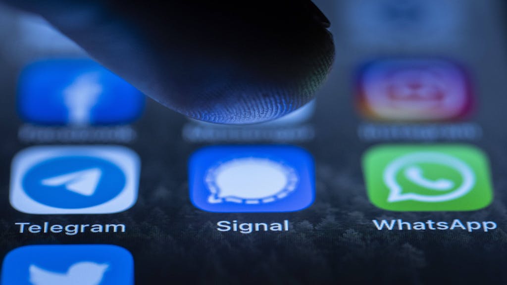Die Logos der Messenger-Dienste Telegram, Signal und WhatsApp sind auf dem Display eines Smartphones zu sehen.