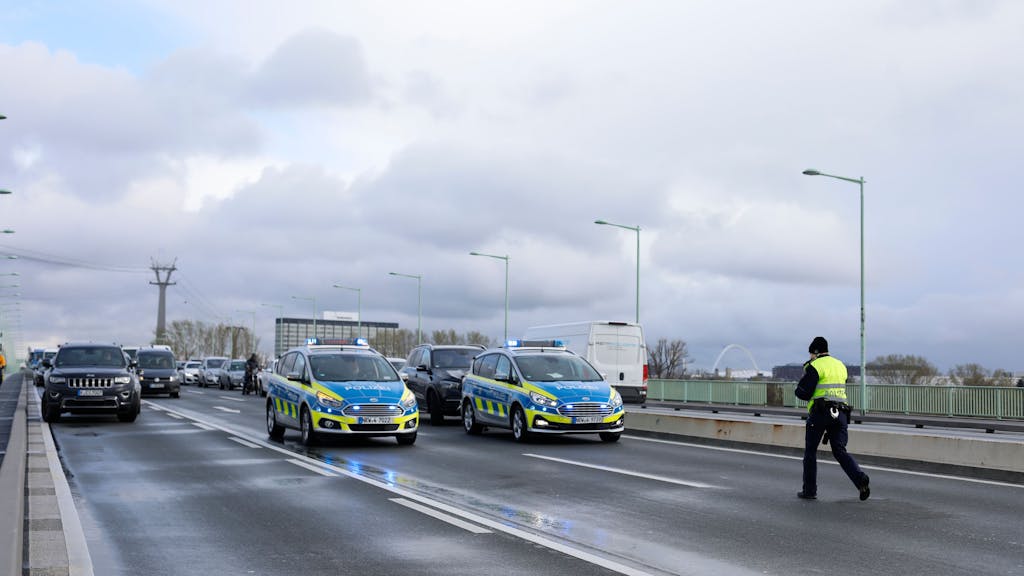 Zwei Polizei-Autos blockieren auf der Zoobrücke in Köln den Verkehr, dahinter warten viele weitere Autos.