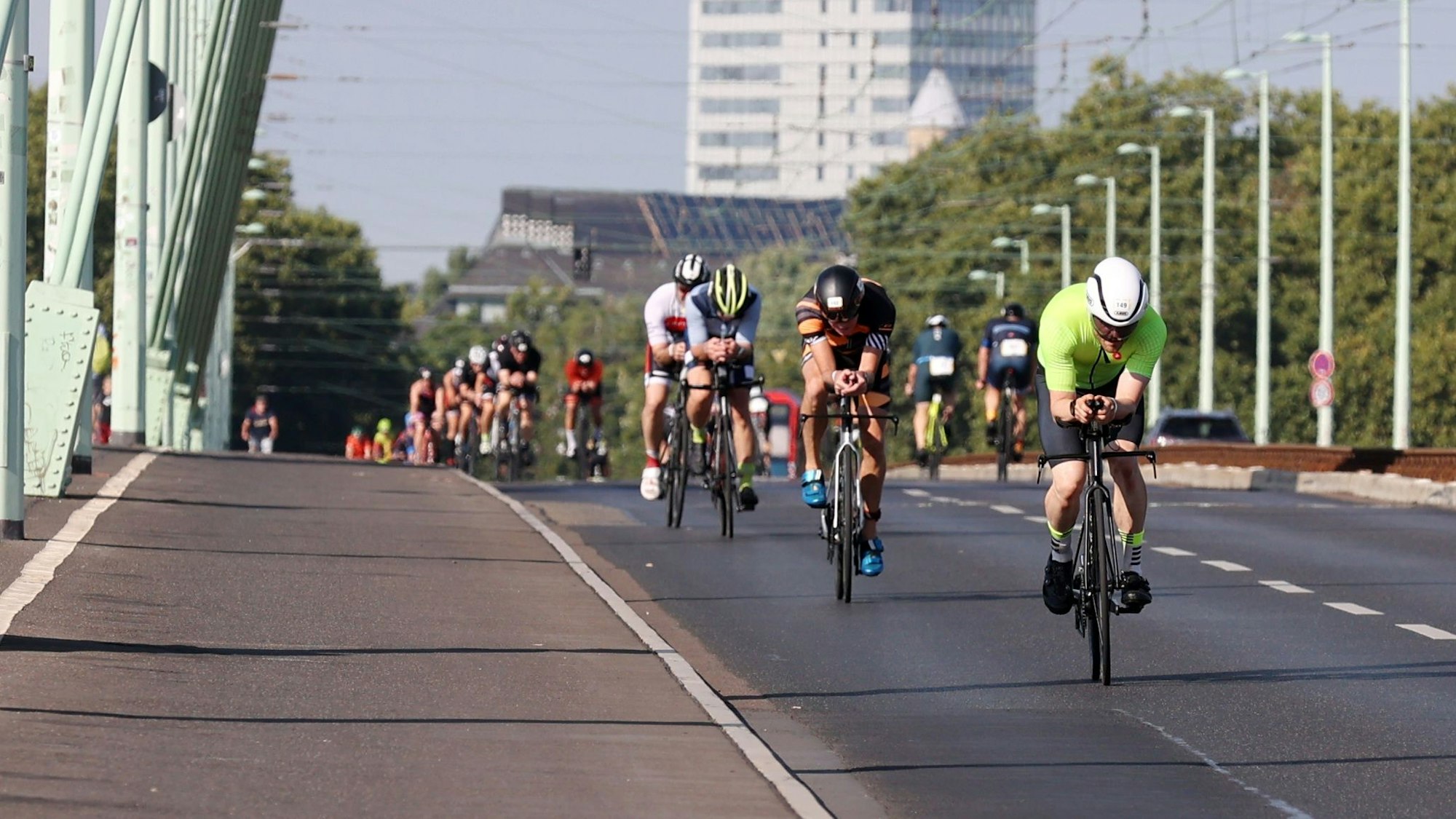 Triathleten sind auf Rennrädern auf der Severinsbrücke unterwegs.