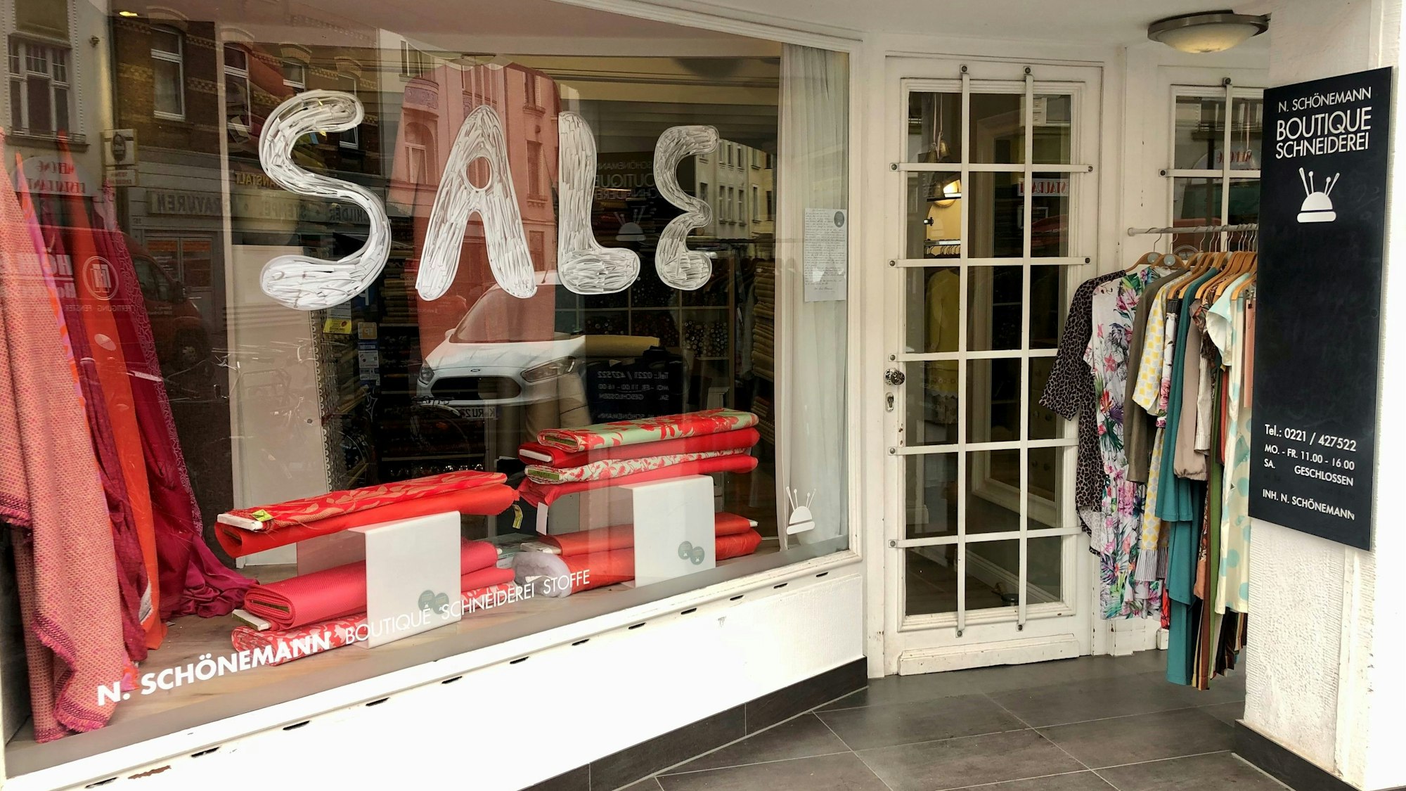 Eine Ladenfront ist zu sehen, auf dem Fenster prangt der Schriftzug Sale.