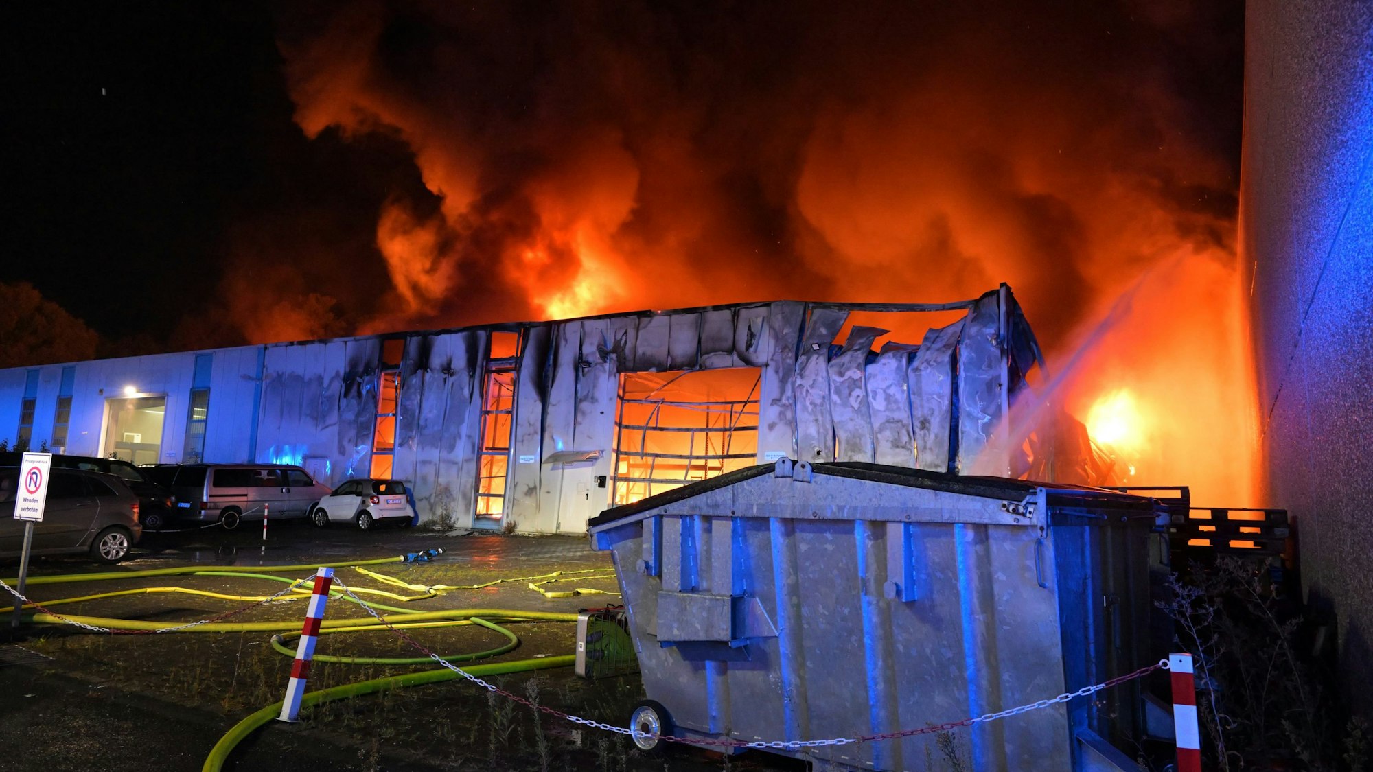 Flammen schlagen aus dem Dach einer Gewerbehalle.