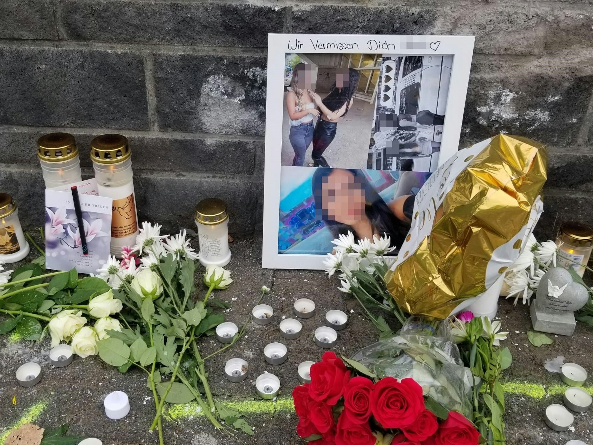 Ein Blumenmeer, eine Gedenkkarte und Fotos des Opfers vom Unfall in Niehl