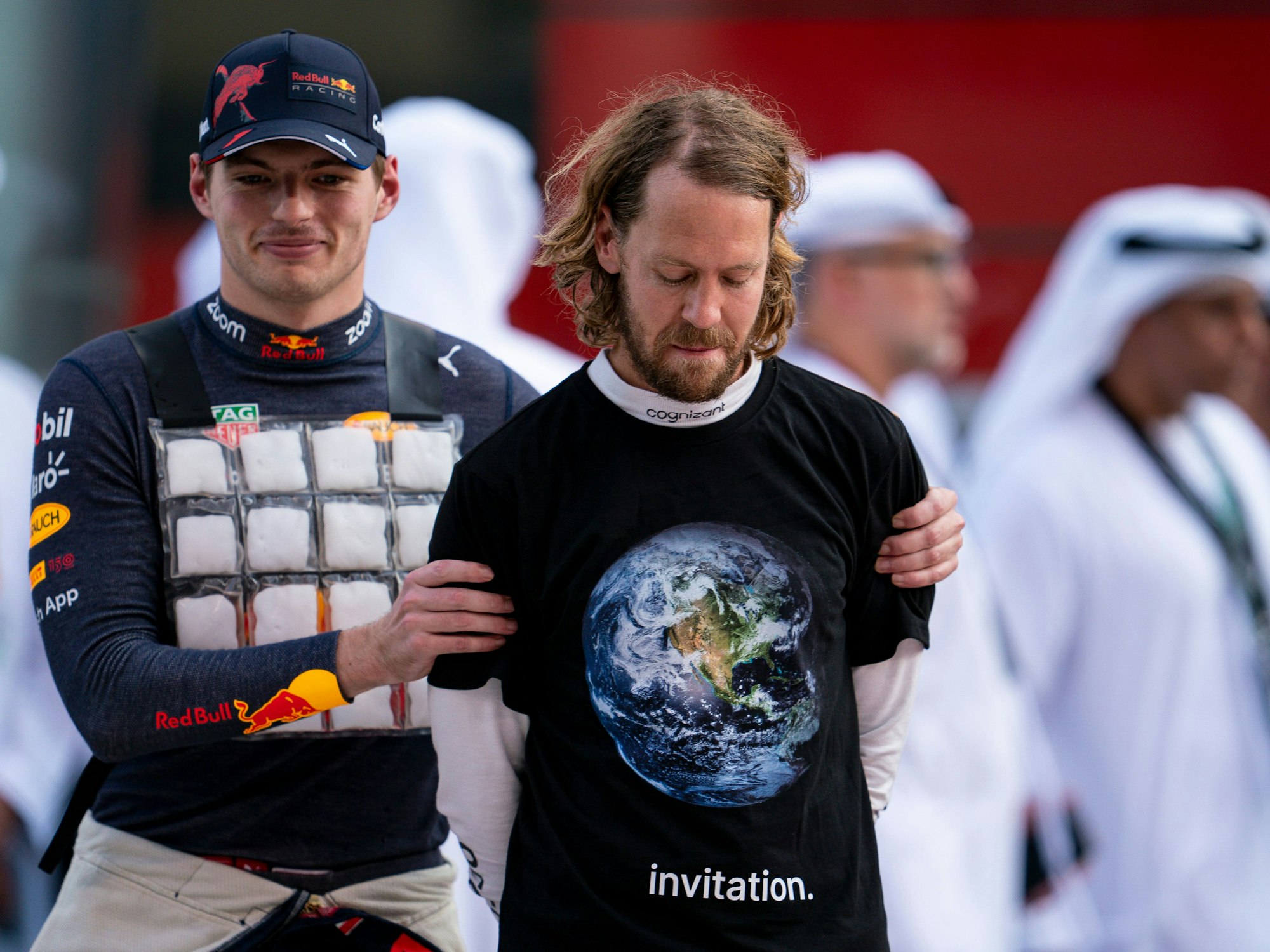 Sebastian Vettel aus Deutschland vomTeam Aston Martin trägt beim Großen Preis von Abu Dhabi ein schwarzes T-Shirt über mit Weltkugel darauf und der Aufschrift «invitation» (Einladung), links daneben Max Verstappen aus den Niederlanden vom Team Oracle Red Bull.