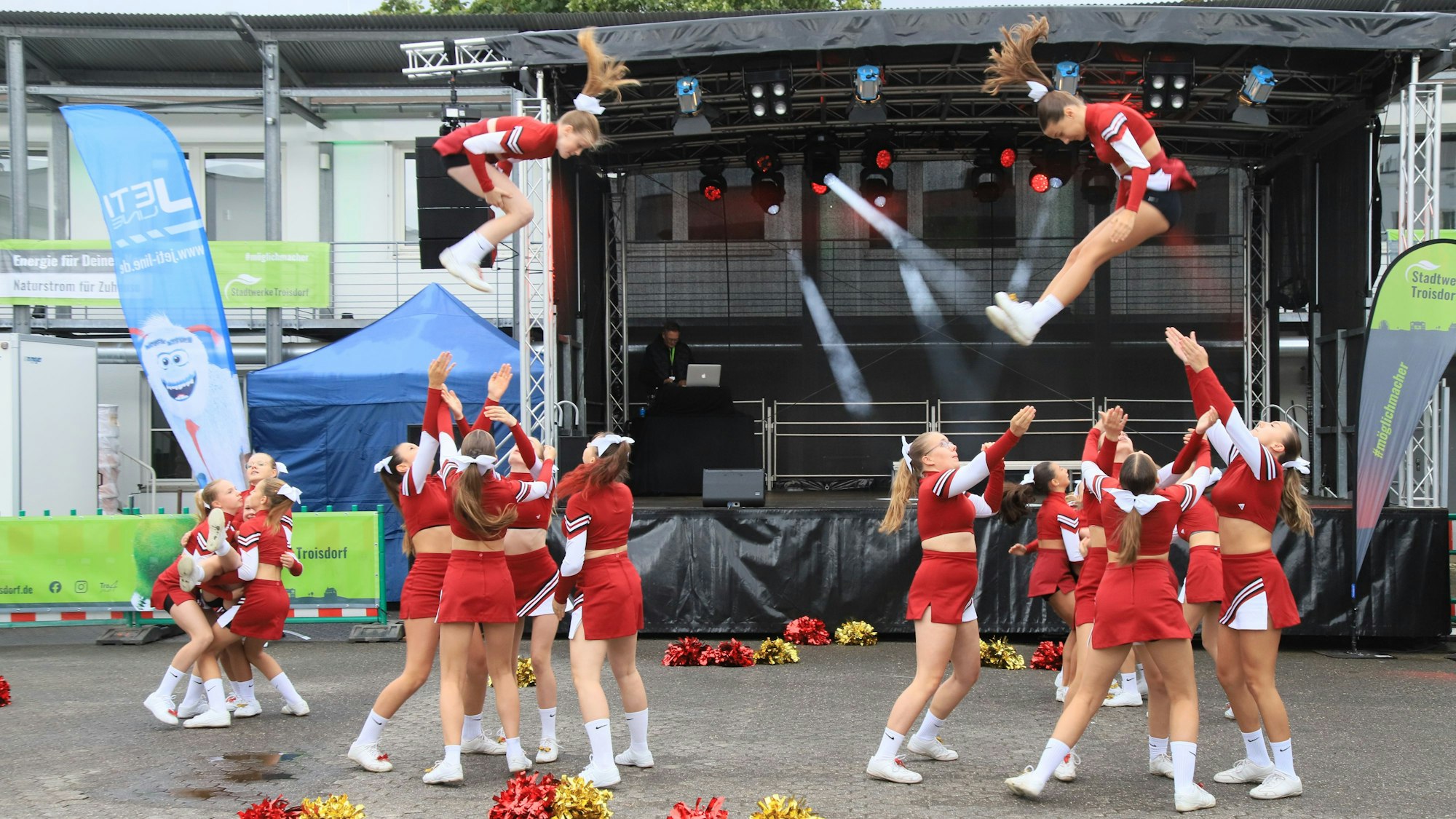 Die Cheerleader der Troisdorf Jets zeigen spektakuläre Akrobatik, bei der Tänzerinnen in der Luft wirbeln.