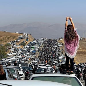 (FILES) This file UGC image posted on Twitter reportedly on October 26, 2022 shows an unveiled woman standing on top of a vehicle as thousands make their way towards Aichi cemetery in Saqez, Mahsa Amini's home town in the western Iranian province of Kurdistan, to mark 40 days since her death, defying heightened security measures as part of a bloody crackdown on women-led protests. - Mahsa Amini was an Iranian woman like any other, but she went down in history as one influential figure for her death on September 16 gave rise to a protest movement which, after six months, continues to affect the society.&nbsp;
