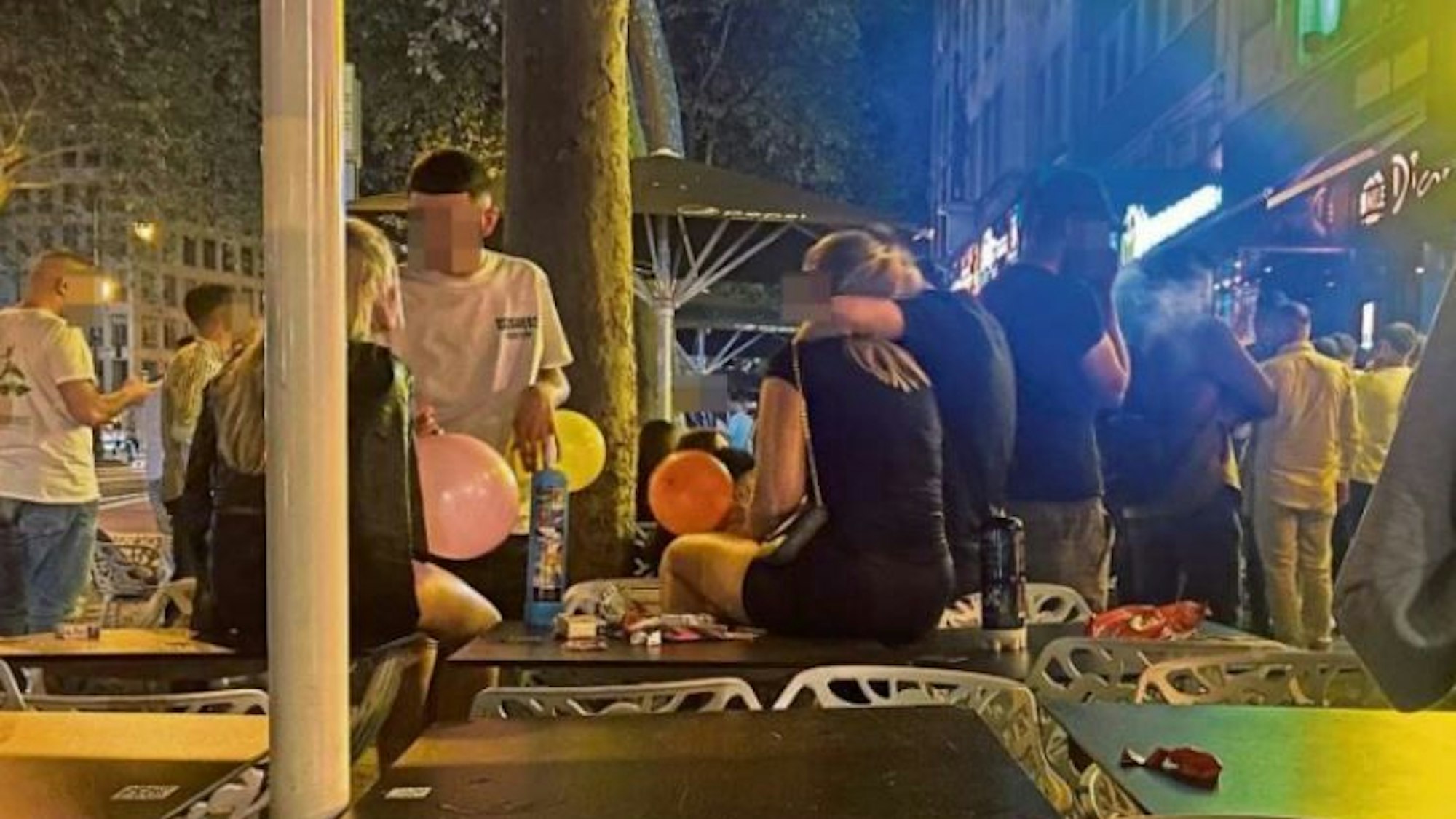Jugendliche auf den Kölner Ringen konsumieren Lachgas aus bunten Ballons.