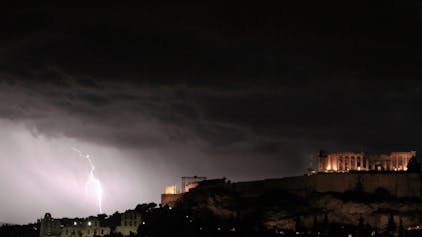 Ein Blitz schlägt in der Nähe der Akropolis, dem Wahrzeichen Athens, ein. In Teilen Griechenlands wird tagelanger Starkregen erwartet. Dies könnte katastrophale Folgen für die Menschen dort haben. (Symbolbild)