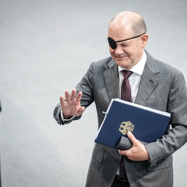Bundeskanzler Olaf Scholz (SPD) mit Redemanuskript im Bundestag. Nach einem Sturz beim Joggen trägt er noch eine Augenklappe.