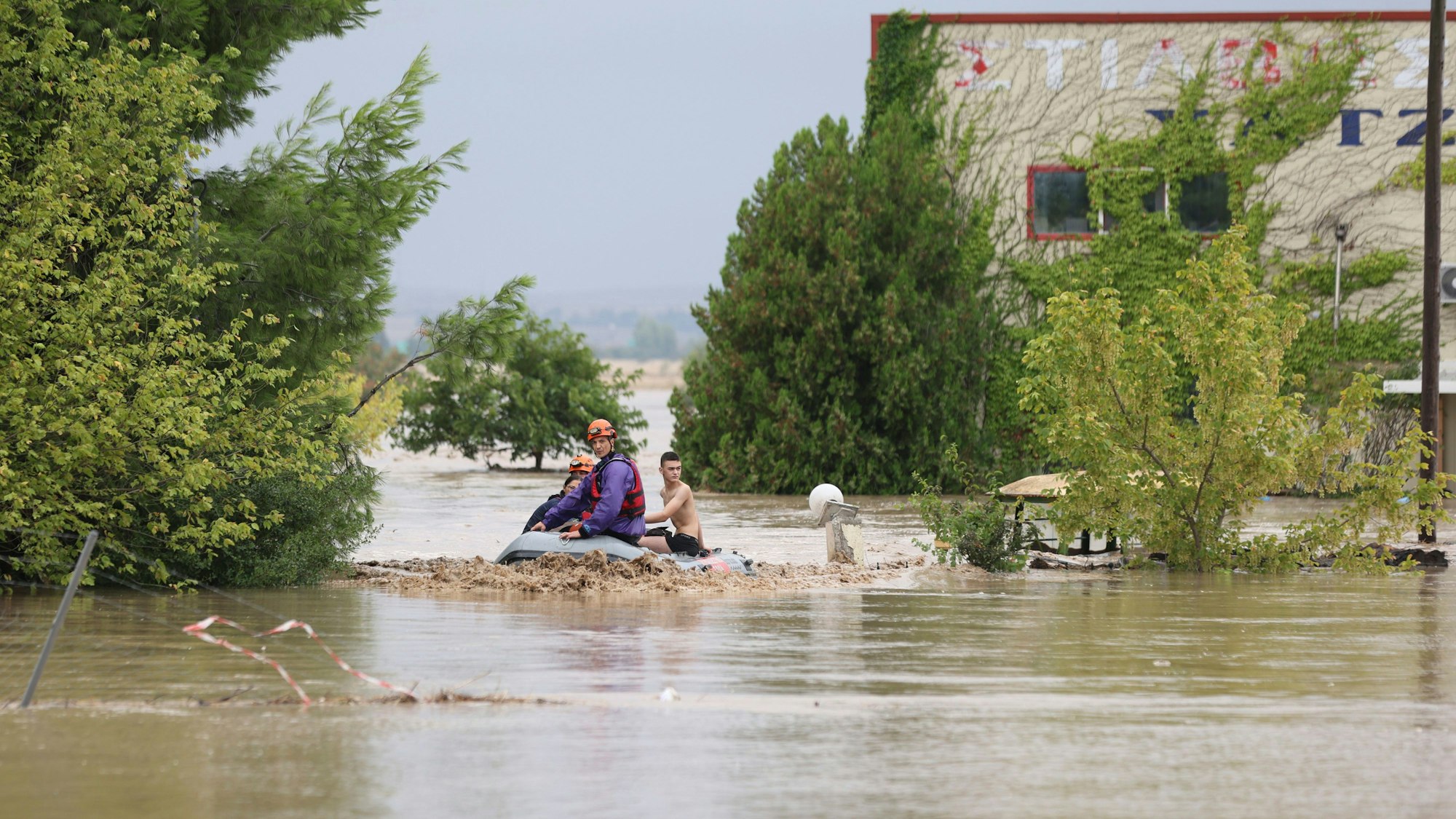 Gemeinde Larissa in Griechenland: Feuerwehrleute mit einem Schlauchboot evakuieren Menschen aus einem überfluteten Gebiet.