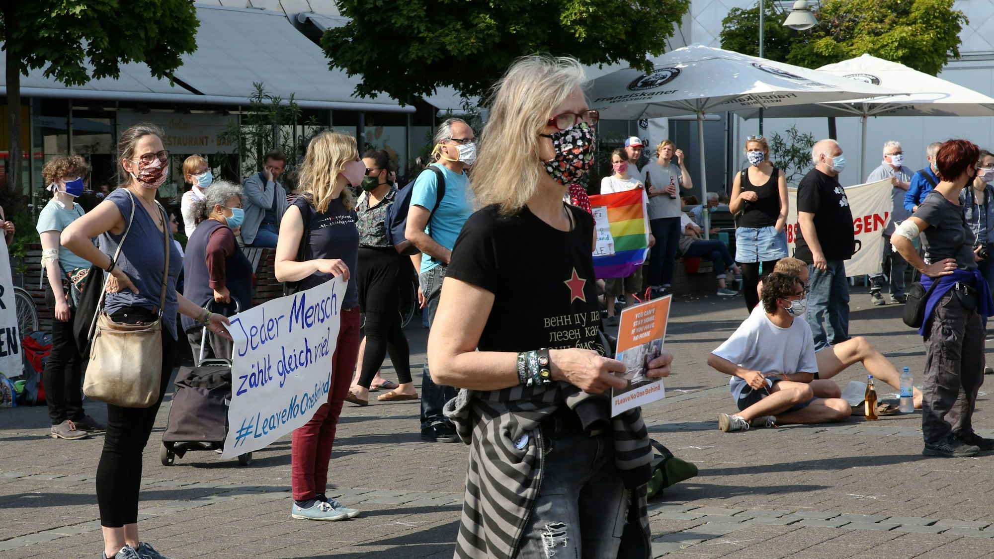 Demonstranten mit Masken und Schildern