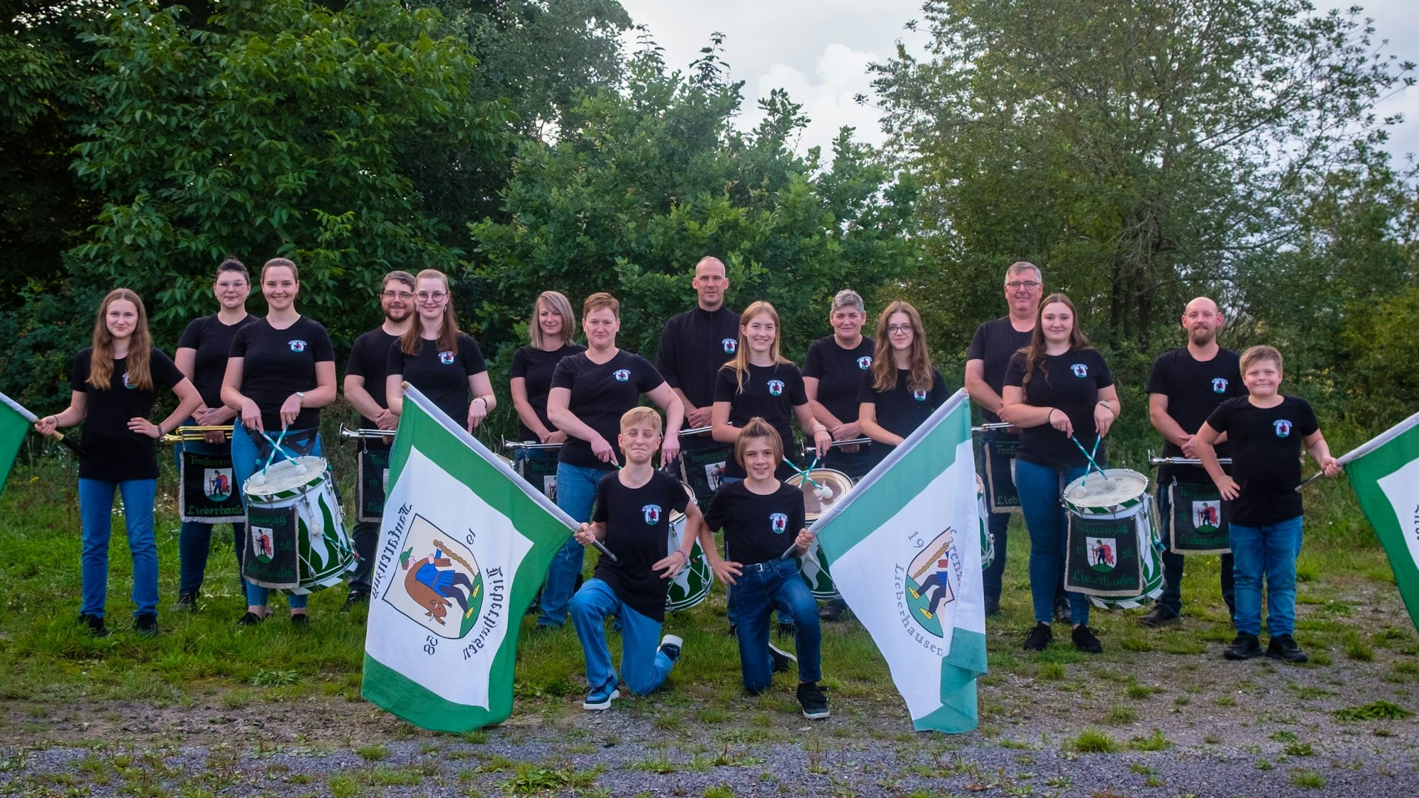 Vor 65 Jahren wurde in der Gummersbacher Ortschaft Lieberhausen der Fanfarenzug gegründet. Am kommenden Samstag wird dieser besondere Geburtstag ordentlich gefeiert. Hier posieren die Musikerinnen und Musiker mit ihren Fahnen im Grünen.