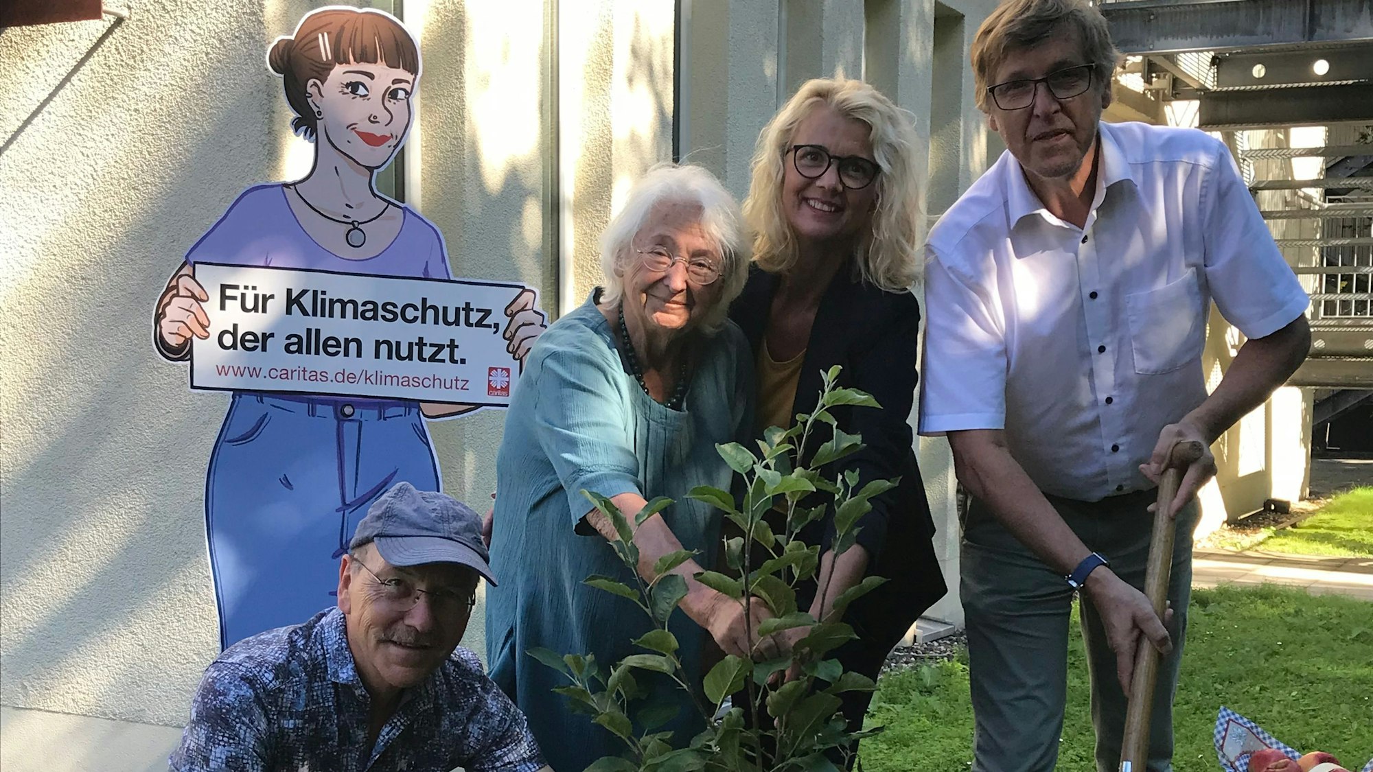 Christian Vater, Renate Graffmann, Carmen Witte-Yüksel und Peter Krücker beim Pflanzen des „Selbstpflückbaums“ (v. l.).