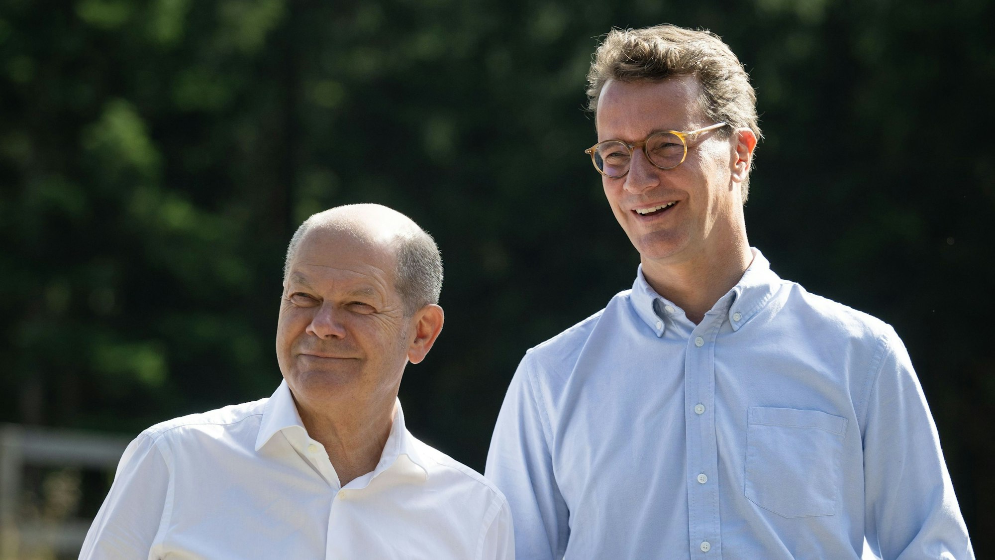 Bundeskanzler Olaf Scholz (SPD, l) und Hendrik Wüst, Ministerpräsident von Nordrhein-Westfalen (CDU) stehen bei einem Besuch eines Bürgerwindparks nebeneinander.