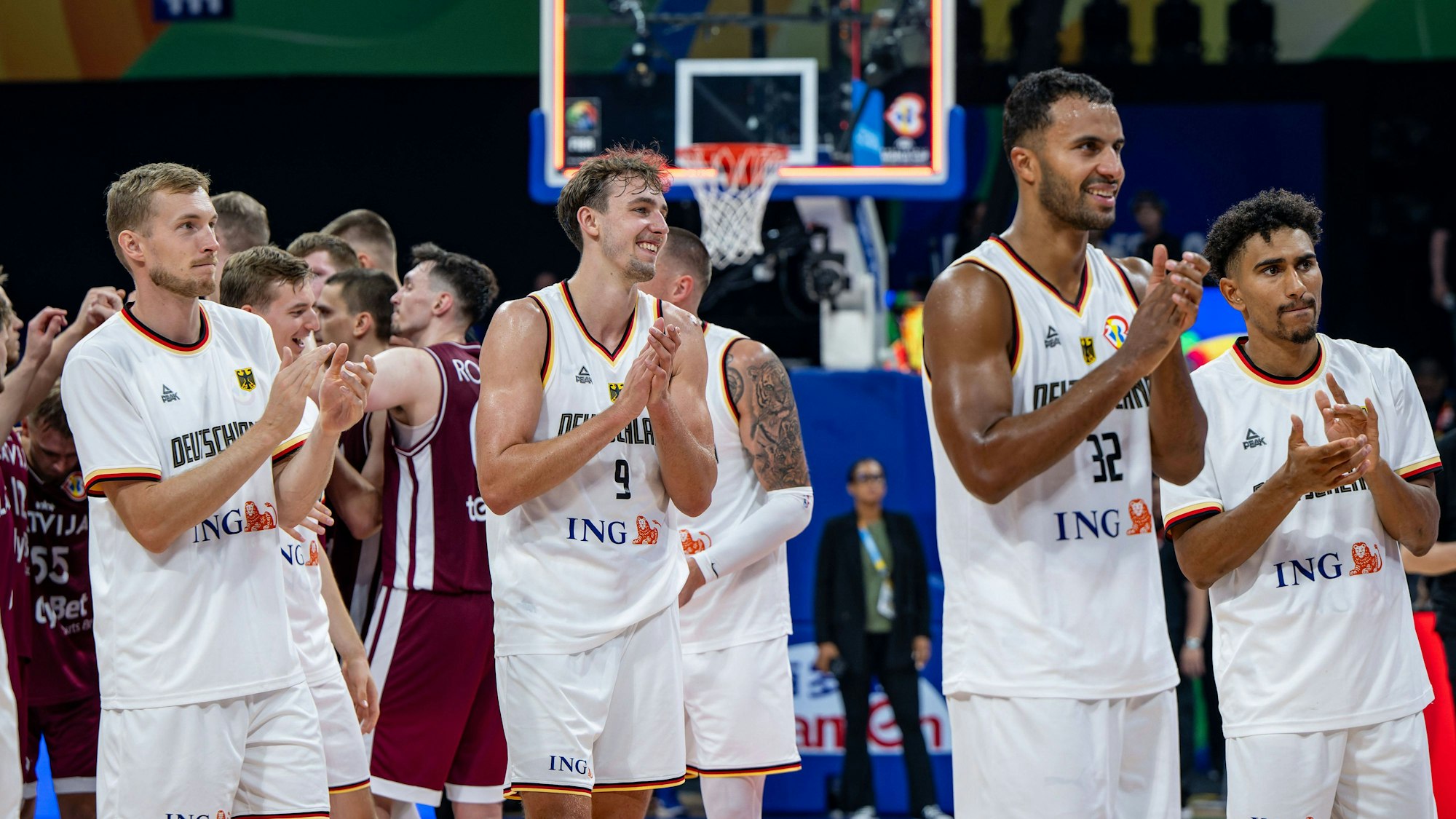 Spieler der deutschen Basketball-Nationalmannschaft jubeln in weißen Trikots nach dem Halbfinaleinzug.