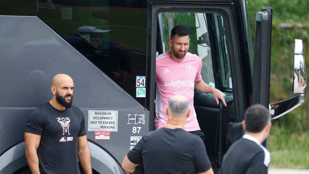 Lionel Messi steigt aus dem Mannschaftsbus aus, Yassine Chueko kontrolliert die Umgebung.