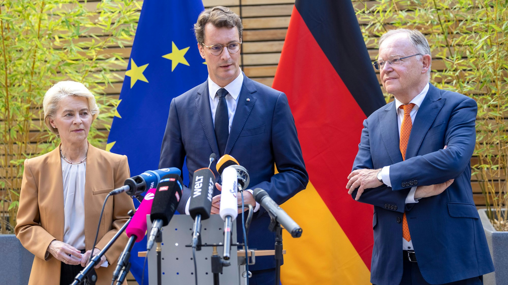 Hendrik Wüst (CDU, M), Ministerpräsident von Nordrhein-Westfalen, spricht bei einem Statement neben Ursula von der Leyen, Präsidentin der Europäischen Kommission, und Stephan Weil (SPD, r), Ministerpräsident von Niedersachsen.