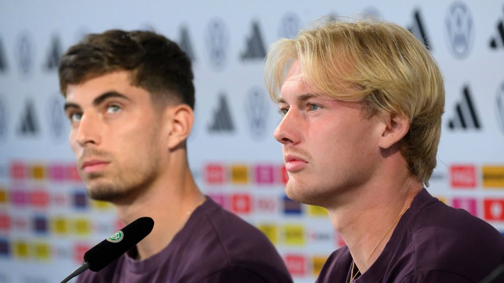 Die Nationalspieler Kai Havertz (l) und Julian Brandt sitzen bei der Pressekonferenz.