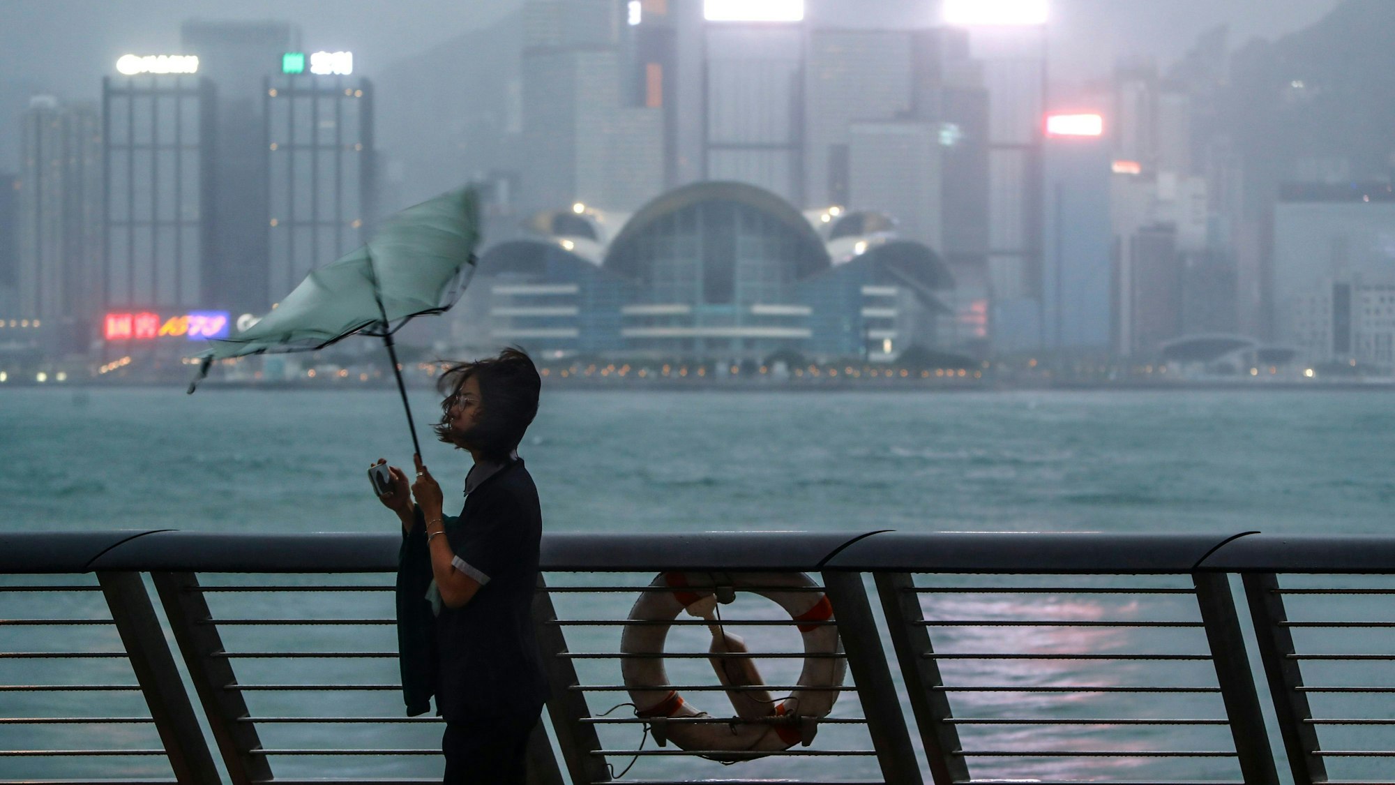 Der Regenschirm einer Frau wird weggeweht, als Taifun „Saola“ mit starkem Wind und Regen auf Hongkong trifft. Begleitet von starken Regenfällen und Windböen hat der Taifun die Küstengewässer Südchinas und Hongkongs erreicht.