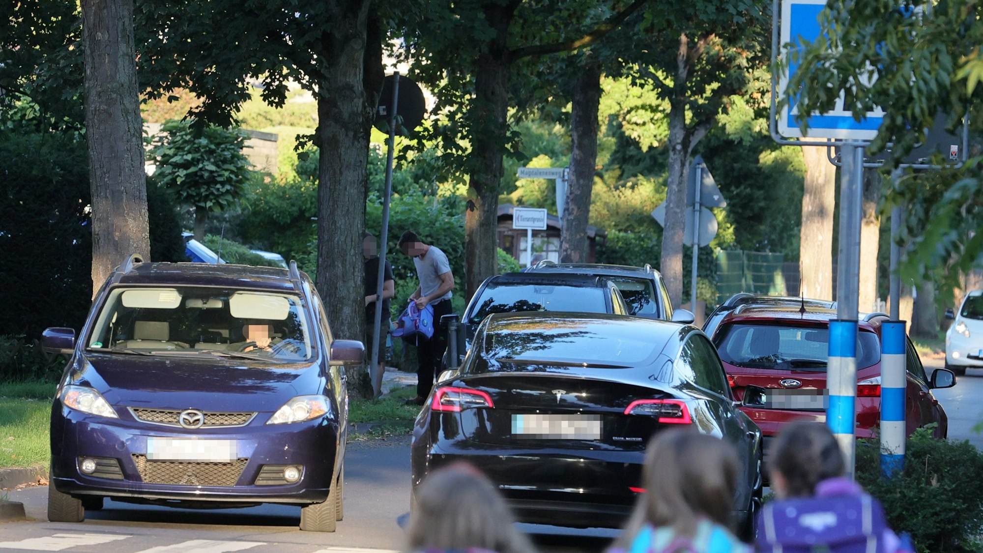 Vor einer Schule stauen sich die Autos - von Eltern, die ihre Kinder direkt vor die Klassenzimmertür fahren wollen.