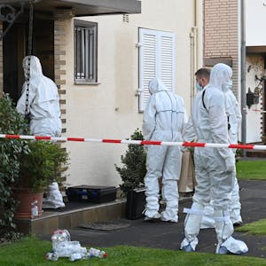 Das Bild zeigt mehrere Kripobeamte in weißen Schutzanzügen vor dem Haus des verstorbenen Rentners.