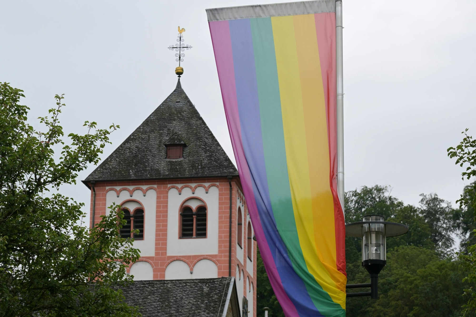 Regenbogenflagge vor einem Kirchturm in Odenthal.