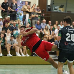 Ein Handballspieler liegt fast quer in der Luft.