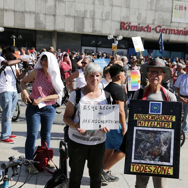 Demonstranten mit Plakaten auf dem Roncalliplatz: „Asylrecht ist Menschenrecht“