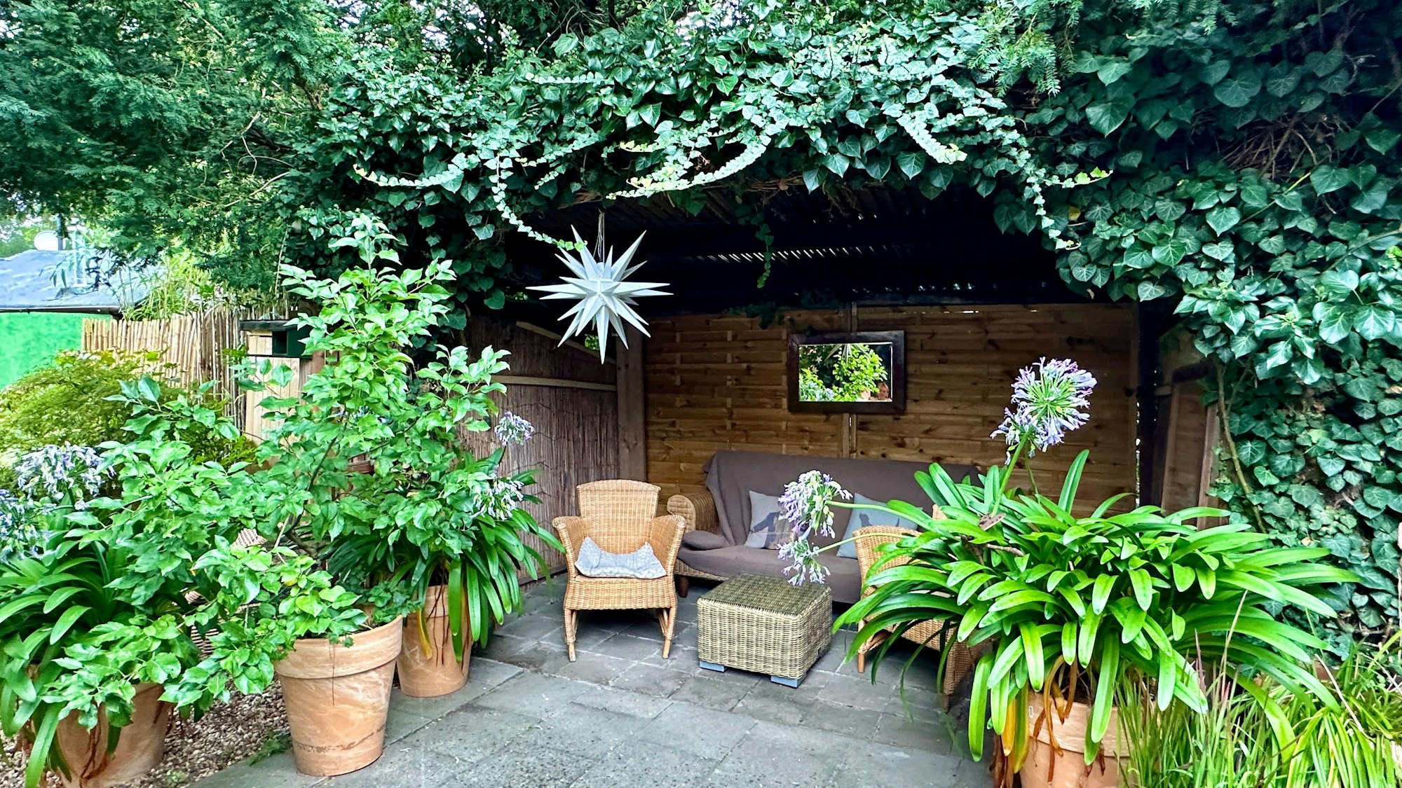 Eine Terrasse mit Gartenmöbeln und Pflanzen.