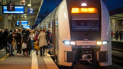 Ein Regionalexpress steht am Kölner Hauptbahnhof, Fahrgäste steigen ein.