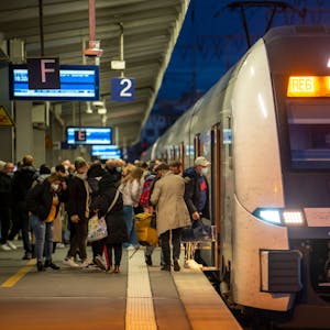 Ein Regionalexpress steht am Kölner Hauptbahnhof, Fahrgäste steigen ein.