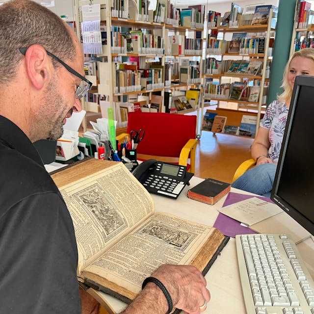 Bibliothekar Marcus Vaillant nimmt eine alte Bibel in Augenschein.