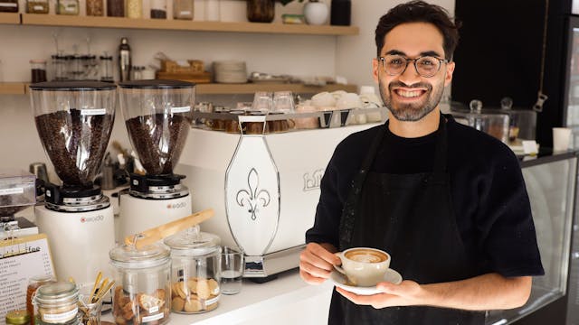 Ibrahim Isiksoy steht mit einer Tasse Cappuccino in seinem Cafe Goldzeit.&nbsp;