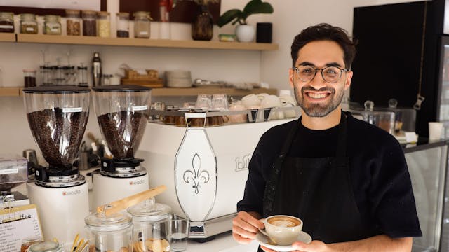 Ibrahim Isiksoy steht mit einer Tasse Cappuccino in seinem Cafe Goldzeit.&nbsp;