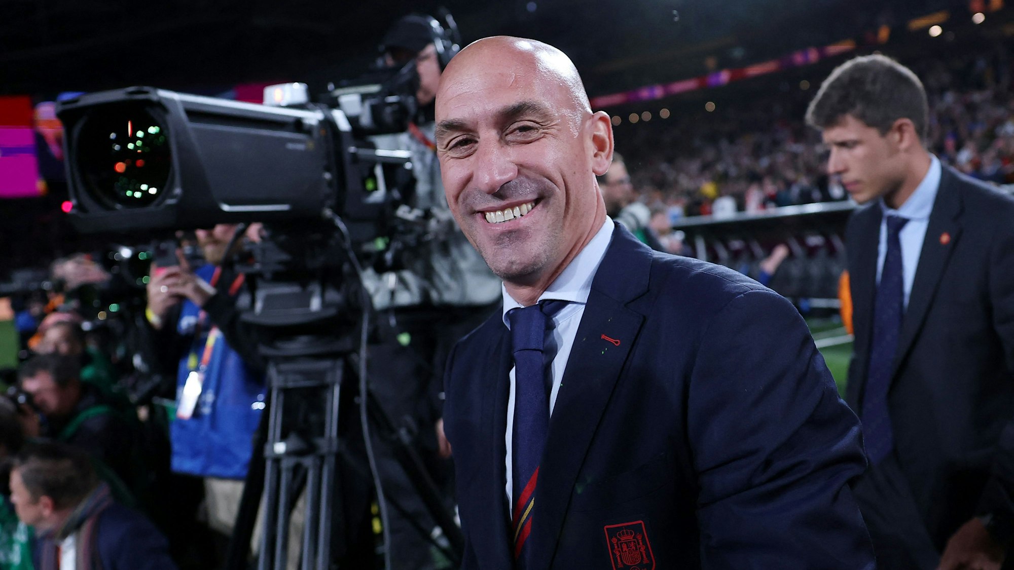 Luis Rubiales lacht in eine Kamera, nachdem die spanischen Fußballerinnen in Australien den Weltmeister-Titel geholt hatten.