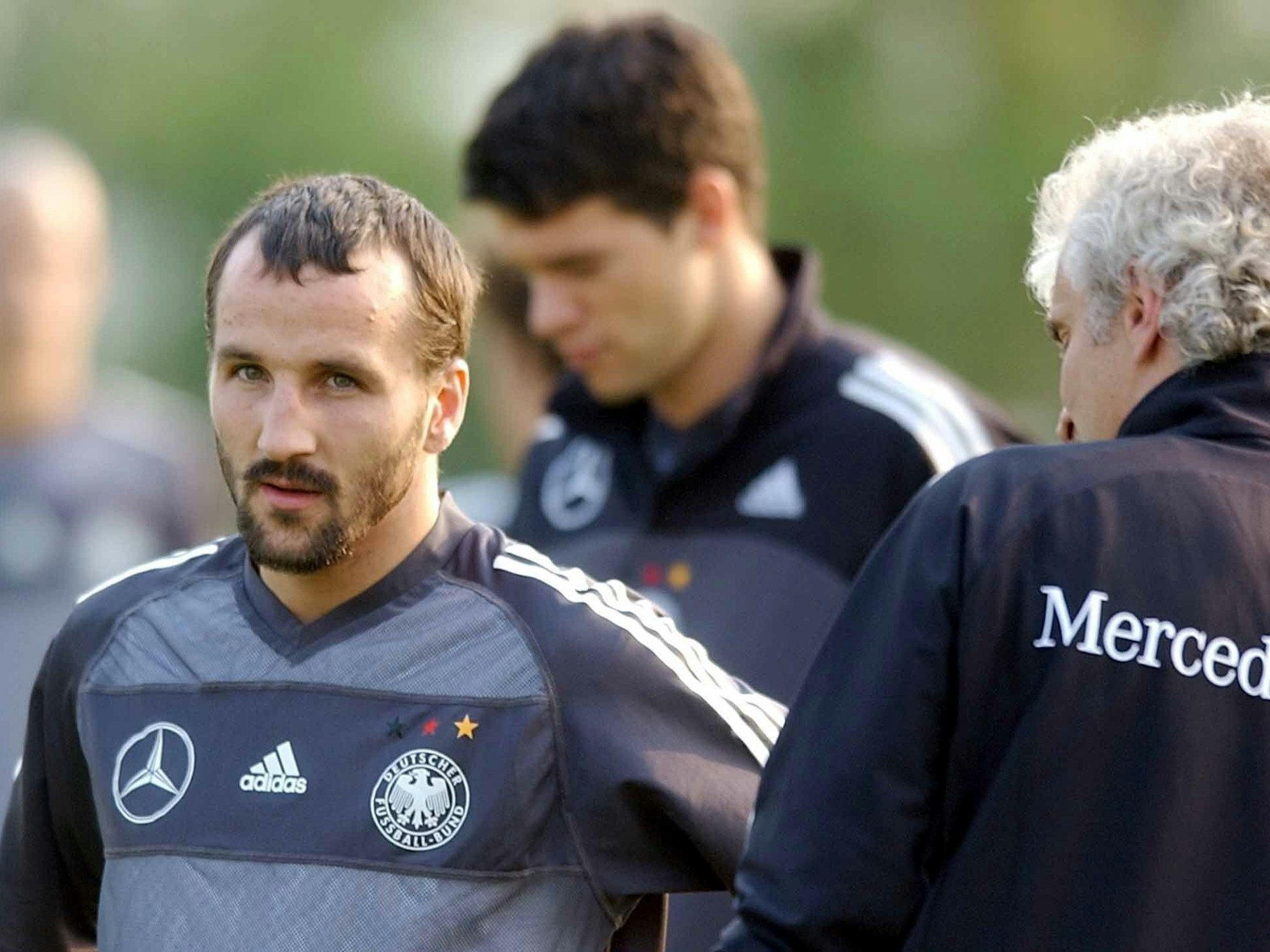 DFB-Teamchef Rudi Völler (r.) spricht während des Trainings mit Jens Jeremies, im Hintergrund Michael Ballack.