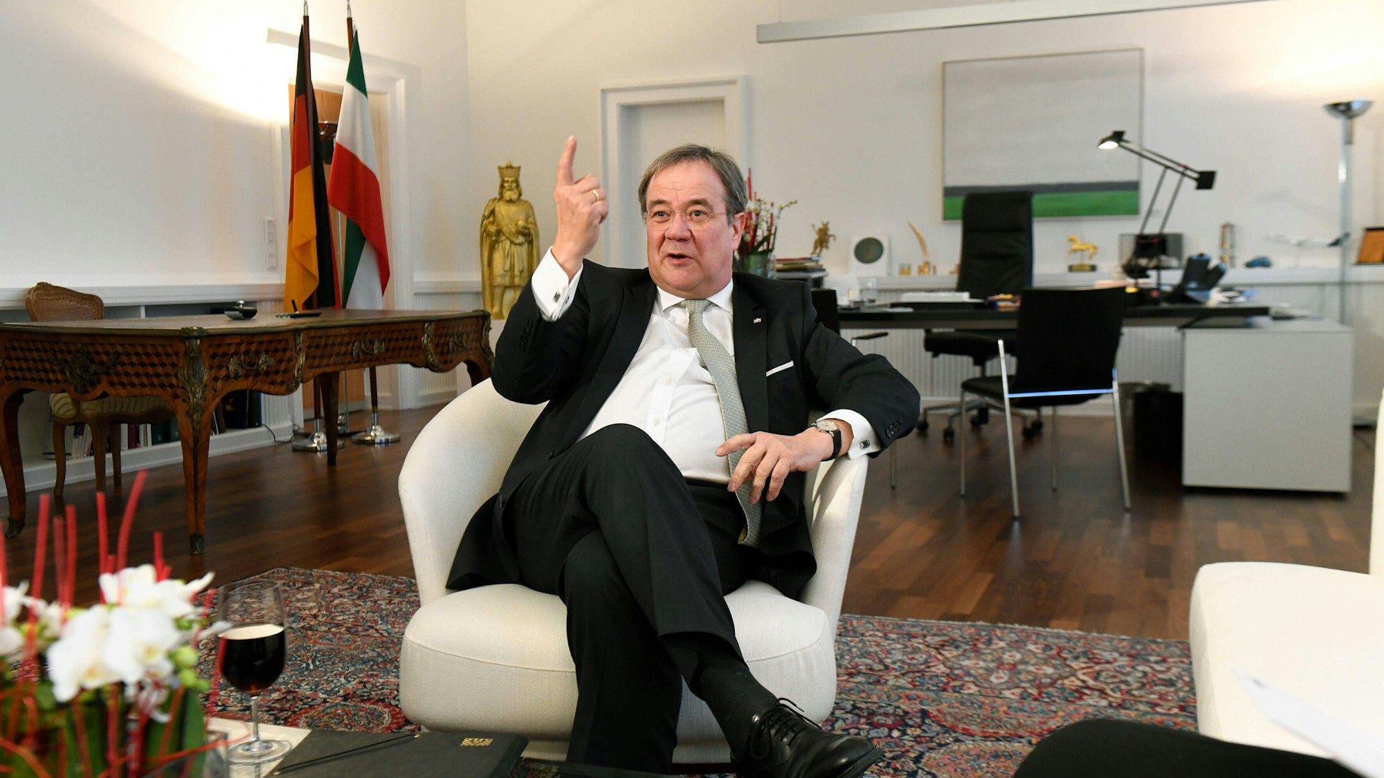 Ex-NRW-Ministerpräsident Armin Laschet ist in einem weißen Sessel in seinem Büro in der Staatskanzlei in einer Gesprächssituation zu sehen.